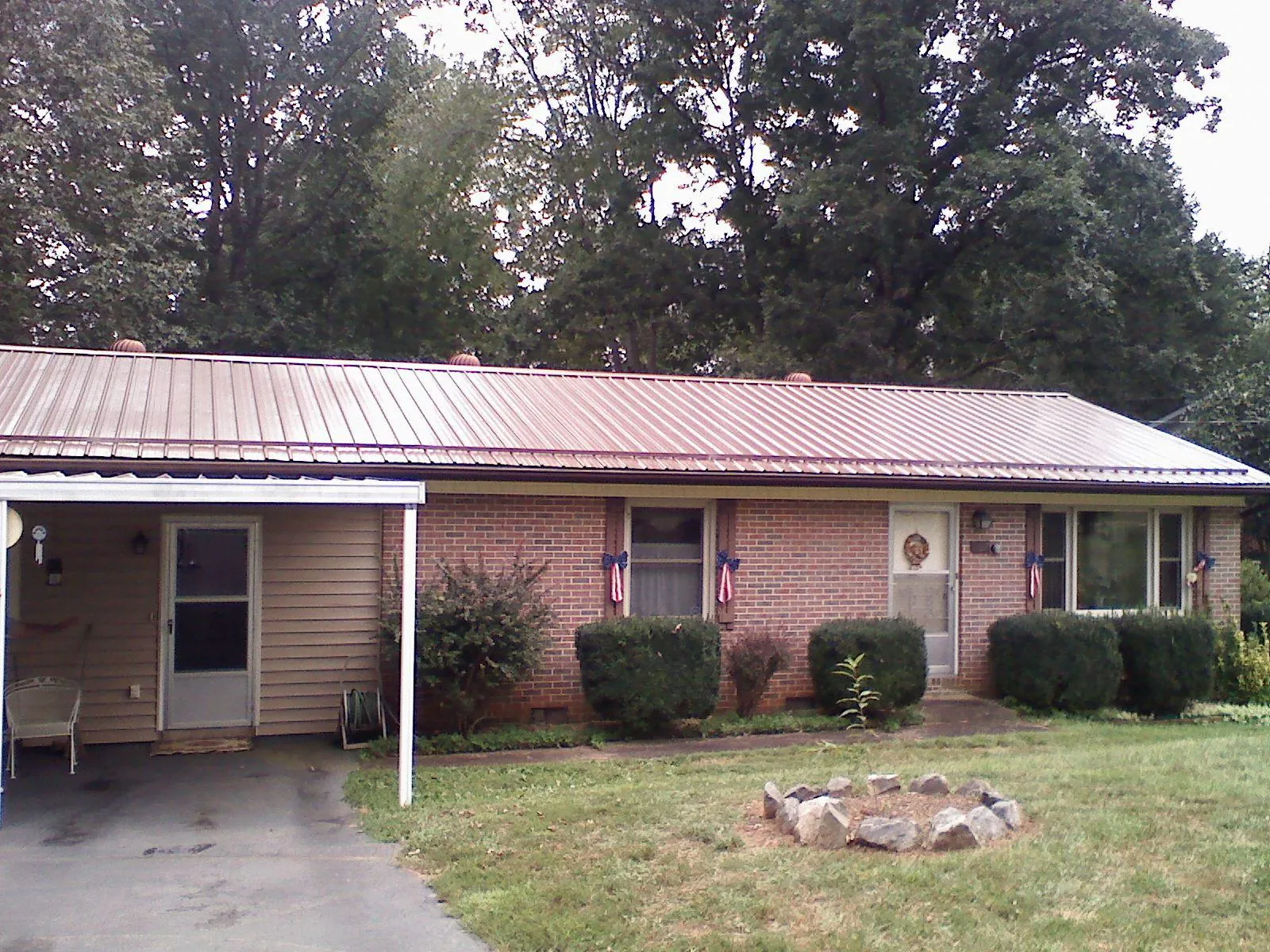 Bronze metal roof and carport on a brick ranch home — Roof Repair work by our crew in Tipton